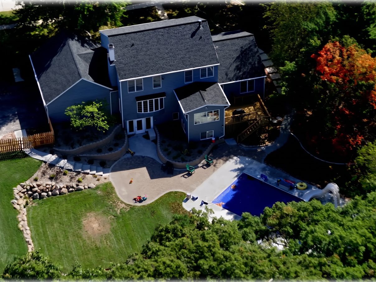 Aerial concept visualization of a pool yard with the court digitally removed and the lawn continued.