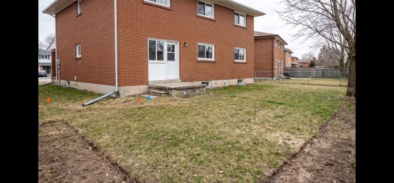 Existing red-brick home backyard before a new landscape concept.
