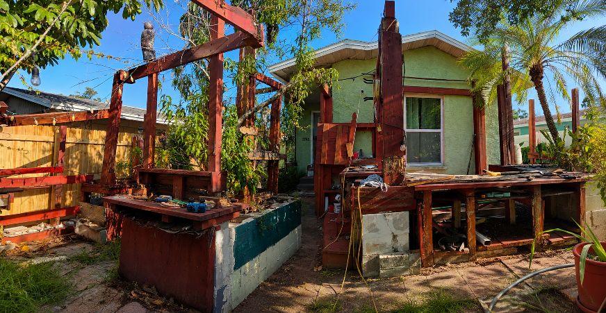 Existing green stucco bungalow yard before a new landscape concept.