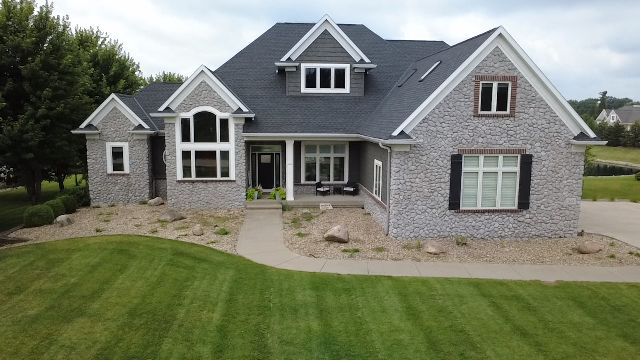 Existing front yard at a large stone home before a new landscape concept.